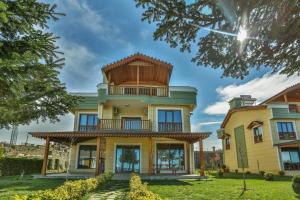 a large yellow house with a balcony at LİFOZ Holiday resort in Trabzon