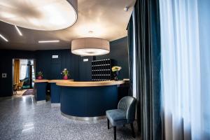 - un bar dans une pièce dotée d'un mur bleu dans l'établissement Hotel Delta, à Montevarchi