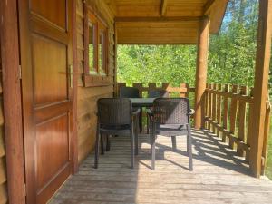 斯蒂格纳Domki Pod Sosnami的门廊上摆放着桌椅