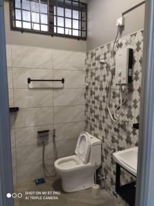a bathroom with a white toilet and a sink at NEW 55 Homestay Corner Lot Spacious House in Bukit Bakri Muar in Muar