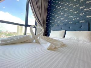 a bed with two swans shaped towels on it at SKS Pavilion Residence by UHA in Johor Bahru