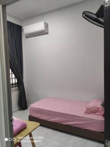 een slaapkamer met een bed met roze lakens en een raam bij NEW 55 Homestay Corner Lot Spacious House in Bukit Bakri Muar in Muar