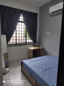 a bedroom with a bed and a window and a table at NEW 55 Homestay Corner Lot Spacious House in Bukit Bakri Muar in Muar