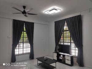 een woonkamer met 2 grote ramen en een plafondventilator bij NEW 55 Homestay Corner Lot Spacious House in Bukit Bakri Muar in Muar