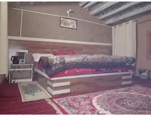 a bedroom with a large bed and a rug at Hotel Mud House Auli, Joshimath, in Joshīmath