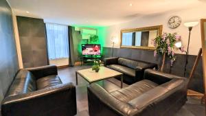 - un salon avec des canapés en cuir et une télévision dans l'établissement The Amsterdam Hotel Apartment in the Center, à Amsterdam 37 autres photos