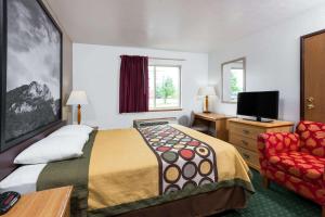Pokój hotelowy z łóżkiem i krzesłem w obiekcie Super 8 by Wyndham Fairmont w mieście Fairmont
