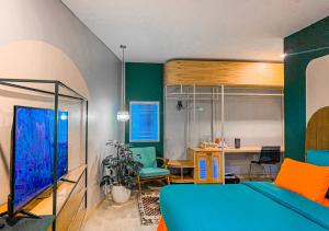 una camera con letto blu e scrivania di Mr A Hotel a Bandung
