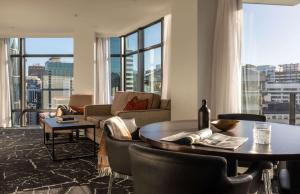 a living room with a table and chairs and a large window at Rydges Wellington in Wellington