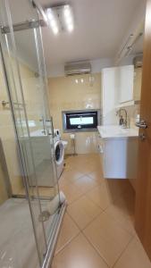 y baño con lavabo y lavadora. en Apartment Laurus en Portorož