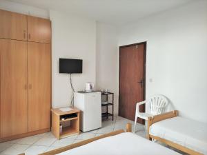 a bedroom with a bed and a tv and a chair at Guest House Violet in Becici