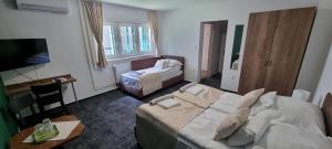 ein Hotelzimmer mit einem Bett, einem Tisch und einem Schreibtisch in der Unterkunft A Fogadó in Bicske