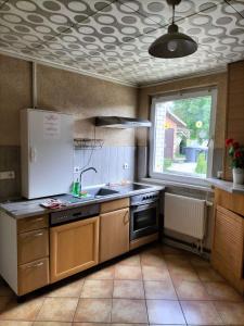 a kitchen with a white refrigerator and a sink at Ferienhaus für Monteure in Bitterfeld-Wolfen in Steinfurth