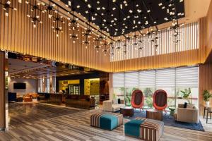 een lobby met banken en stoelen in een gebouw bij Ramada Encore by Wyndham Indore Nipania in Indore