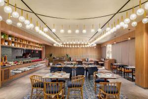 un restaurant avec des tables et des chaises et une cuisine dans l'établissement Ramada Encore by Wyndham Indore Nipania, à Indore