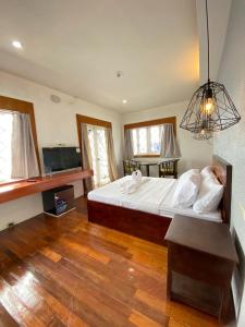 um quarto com uma cama grande e uma televisão em Dumaguete Seafront Hotel em Dumaguete