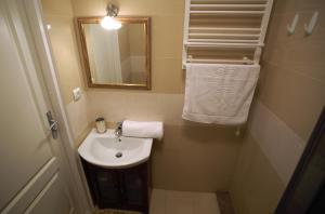 ein Badezimmer mit einem Waschbecken, einem Spiegel und Handtüchern in der Unterkunft Apartament MGM Janów Podlaski in Janów Podlaski