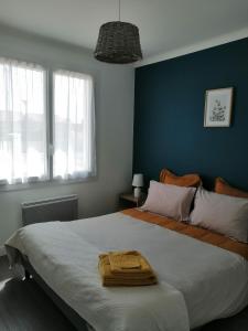 una camera con un grande letto con una parete blu di Le Barbatrin a Barbâtre