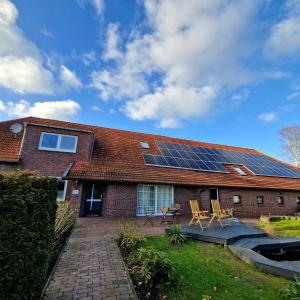 une maison avec des panneaux solaires sur le toit dans l'établissement Friesenparadies FRI-Südliches Friesland, à Bockhorn