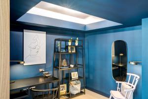 a blue room with a desk and a mirror at Apex Waterloo Place Hotel in Edinburgh