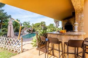 un patio con mesa y sillas junto a una piscina en Villa Concha by Indigo en Benagil