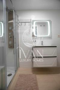 een badkamer met een wastafel en een spiegel bij Casa Paraty Ivan Luxury Homes 9ª Pta Sur 1ª Línea in Oropesa del Mar