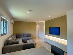 a living room with a couch and a flat screen tv at Studios Pantelis Corfu in Ýpsos