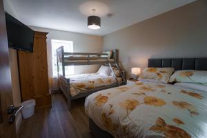 a bedroom with a bed and a bunk bed at Carrig Island Lodge in Ballylongford