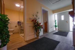 uma casa de banho com um vaso de flores num corredor em Carrig Island Lodge em Ballylongford