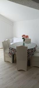 a dining room with a table and two chairs at Feel Good Apartment Rab in Mundanije