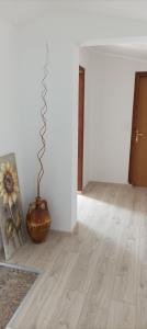 a living room with a wooden floor and a vase at Feel Good Apartment Rab in Mundanije