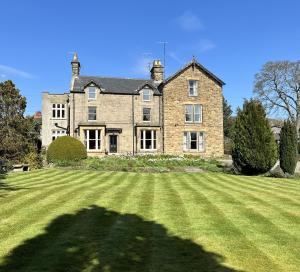 a large brick house with a large grassy yard at The Beeches - Chatsworth Apartment No 1 - Sleeps 2 in Baslow