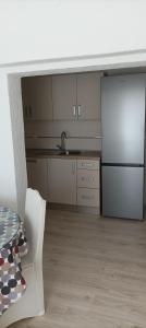a kitchen with a white refrigerator and a sink at Feel Good Apartment Rab in Mundanije