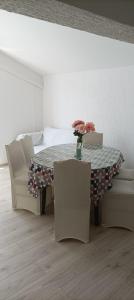 a dining room with a table and two chairs at Feel Good Apartment Rab in Mundanije