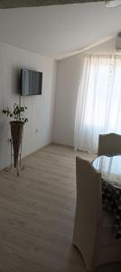 a white room with a table and a television on the wall at Feel Good Apartment Rab Mundanije 131 in Mundanije
