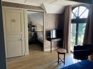 ein Zimmer mit einem Spiegel und ein Schlafzimmer mit einem Bett in der Unterkunft Le Castel de Bréhémont in Bréhémont