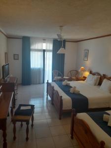 um quarto de hotel com duas camas e uma secretária em Cornucopia Hotel em Xaghra