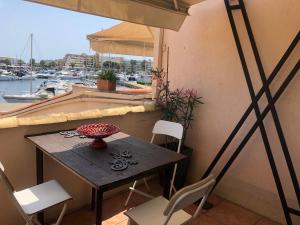 een tafel en stoelen op een balkon met uitzicht op een haven bij Résidence Port Soleil B453 in Cap d'Agde