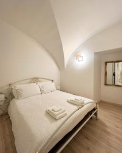 ein Schlafzimmer mit einem Bett mit zwei Handtüchern darauf in der Unterkunft L’Arco sul Lago • Gold Apartment in Castro