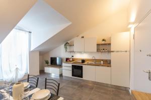 a kitchen with white cabinets and a table and chairs at KHL APARTMENTS in Milan