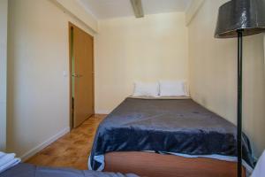 a small bedroom with a bed in a room at QuartosCotao in Agualva