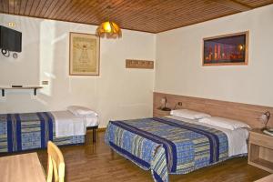 Cette chambre comprend 2 lits et une table. dans l'établissement Albergo Ristorante Iris, à Auronzo di Cadore