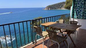a table and chairs on a balcony overlooking the ocean at LES TERRASSES de Cala Llevado in Tossa de Mar