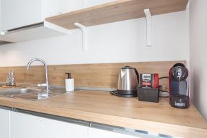 un bancone della cucina con lavandino e macchinetta del caffè di KHL APARTMENTS a Milano