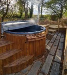 a hot tub sitting on a patio in a yard at Fox Lodge at Heygates Lodging - with hot tub in Yelvertoft +8 photos