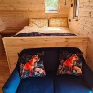 a bed in a tiny house with two pillows at Fox Lodge at Heygates Lodging - with hot tub 