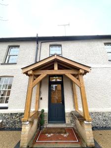 uma entrada em madeira para um edifício com uma porta preta em Moulton Lawn House B&B 