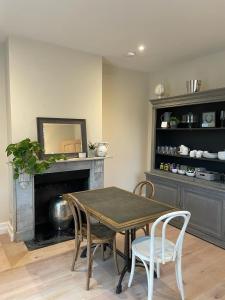 a dining room with a table and chairs and a fireplace at Moulton Lawn House B&B 