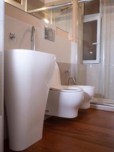 bagno bianco con servizi igienici e lavandino di Dimora NiLu' a Margherita di Savoia