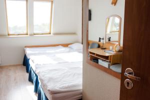 Zimmer mit 2 Betten, einem Waschbecken und einem Spiegel in der Unterkunft Hotel Kliper in Władysławowo